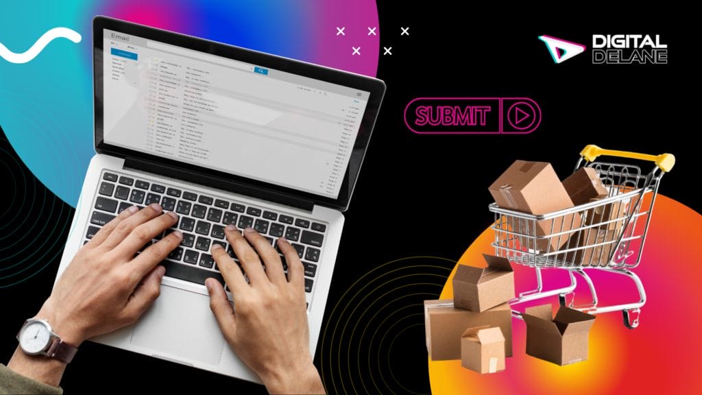 person typing on a laptop keyboard with a shopping cart carrying boxes next to it