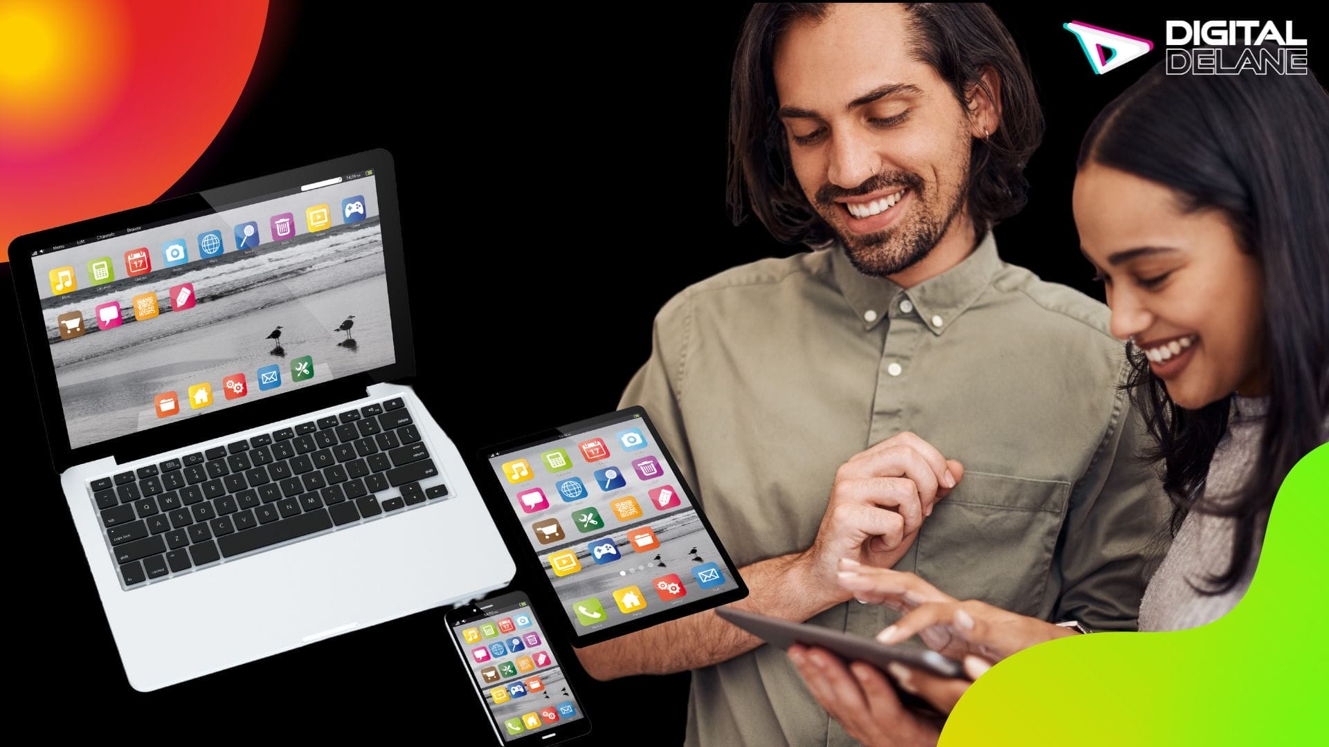 A man and woman sitting at a table, focused on their phones and laptop screens.