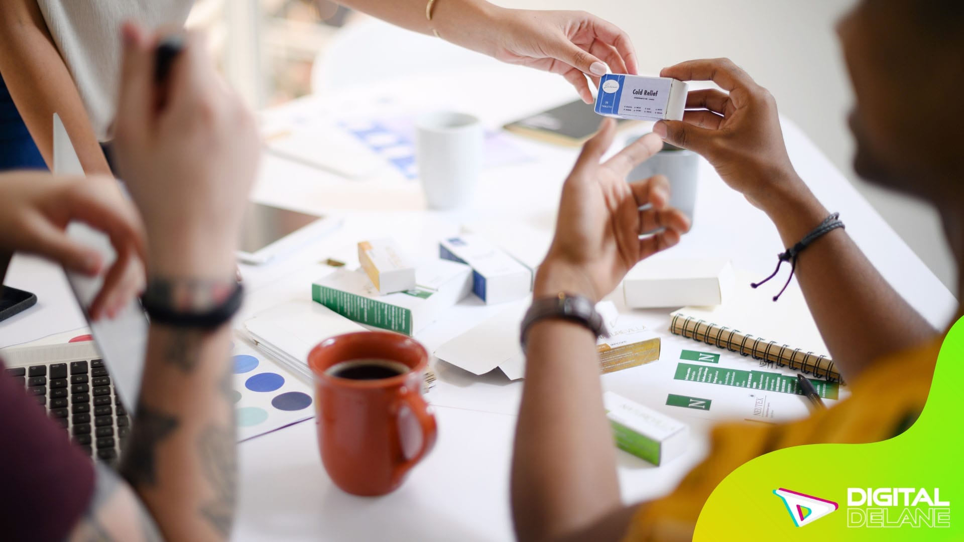 A group of individuals engaged in discussion, holding cards and papers around a table, indicating collaboration and decision-making.
