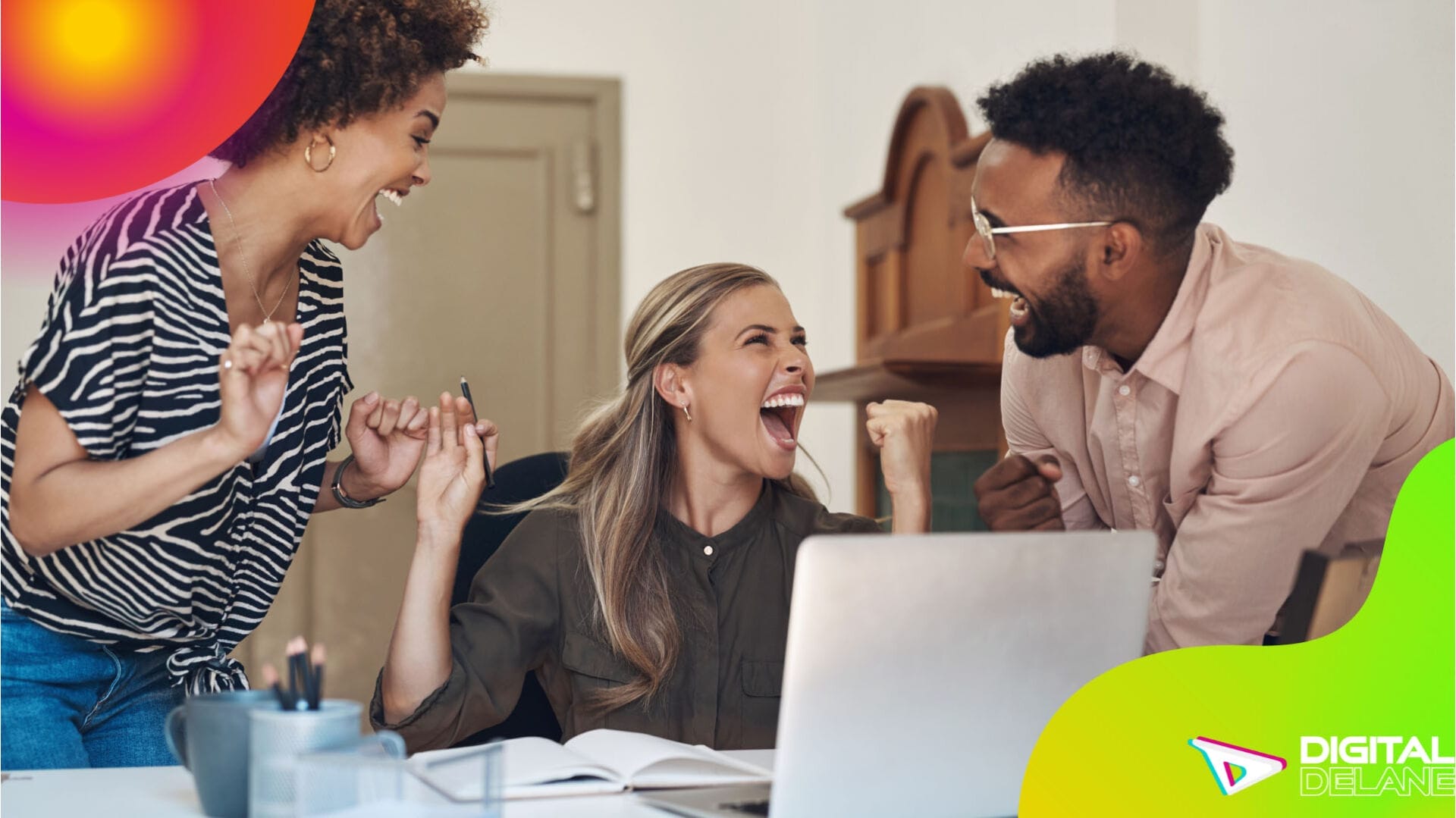 Three individuals joyfully engage with a laptop, highlighting the advantages of programmatic advertising.