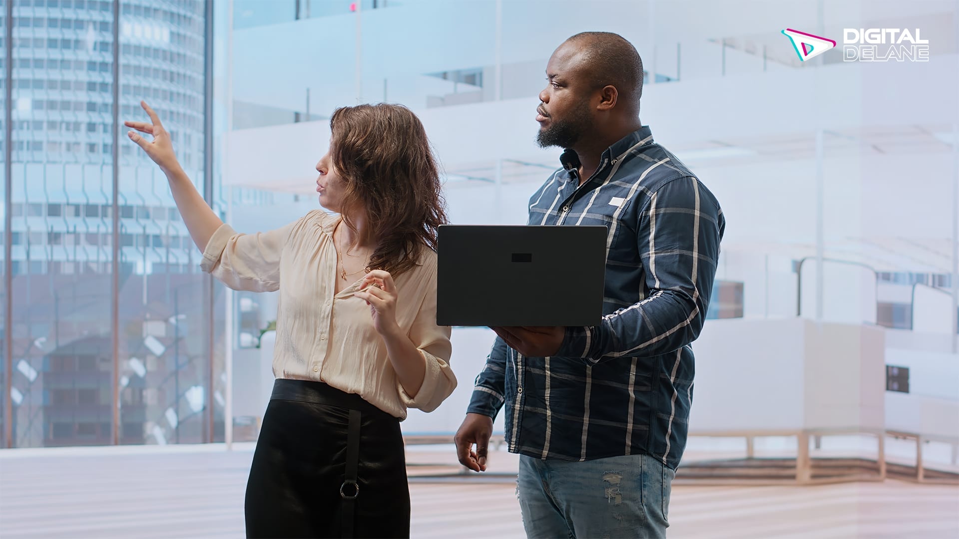 A man and woman discussing a laptop, representing buyer and seller in a business negotiation.