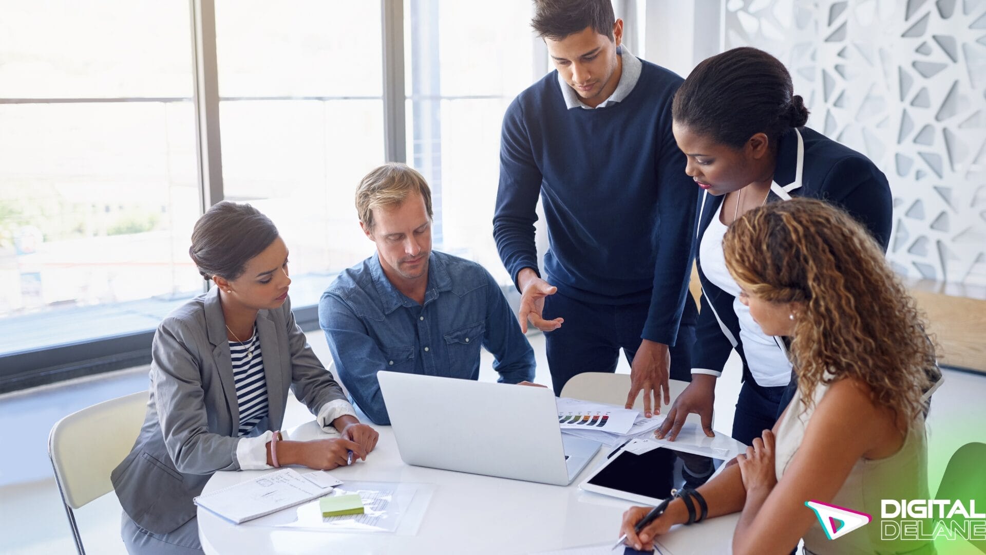 A group of business professionals collaborating on a laptop to enhance their digital marketing strategies.