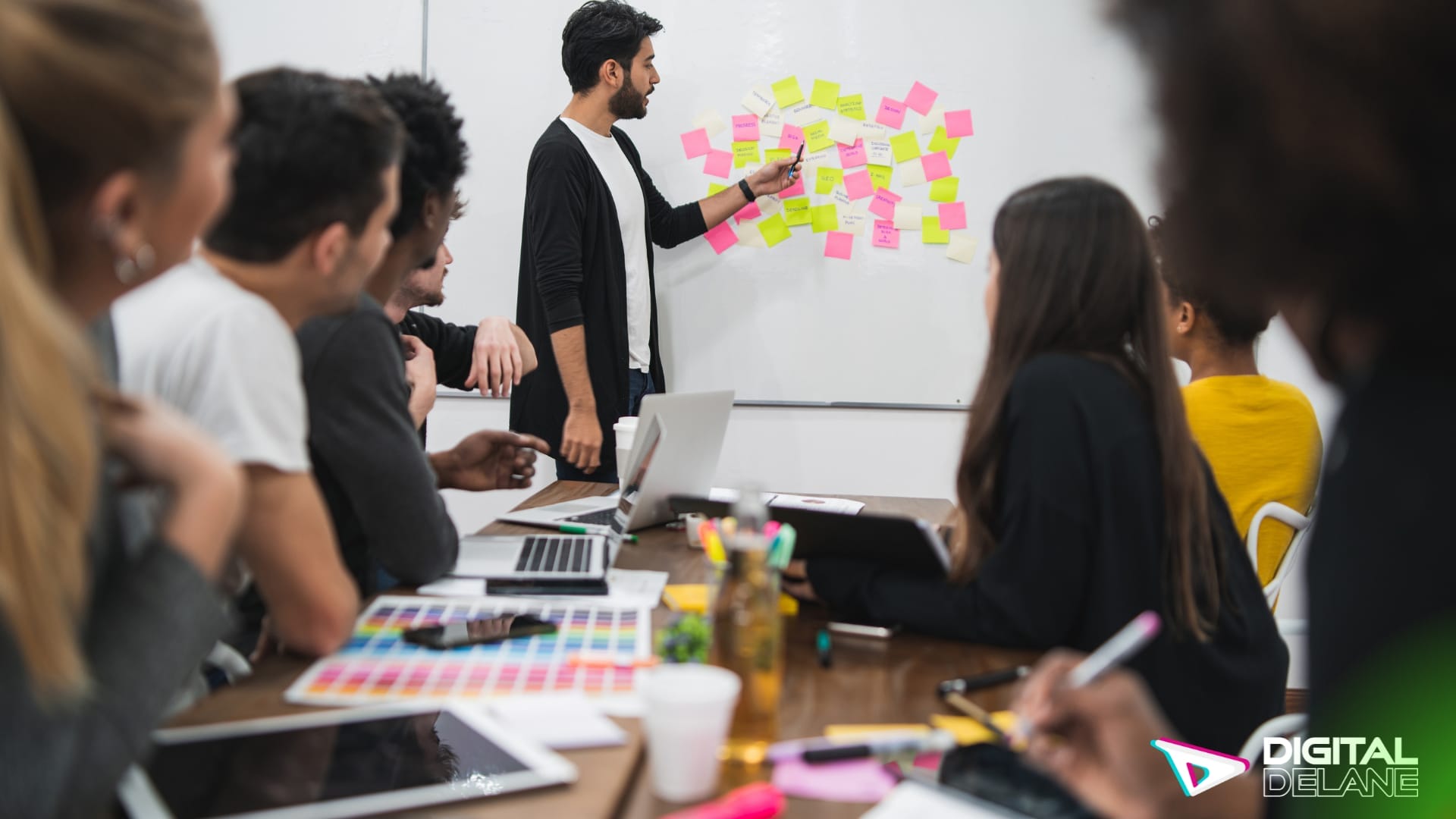 A diverse group of professionals collaborates in a meeting room, surrounded by sticky notes on a whiteboard, strategizing effectively.