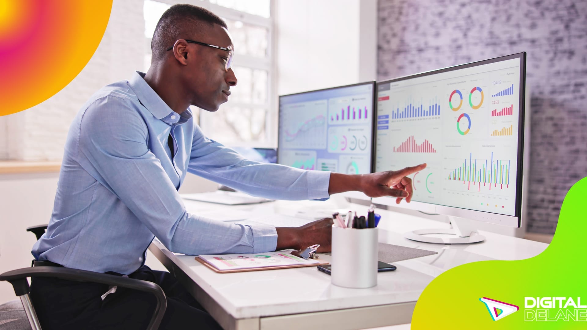 A man at a desk with two monitors and a computer screen, analyzing real-time performance metrics for strategic improvement.