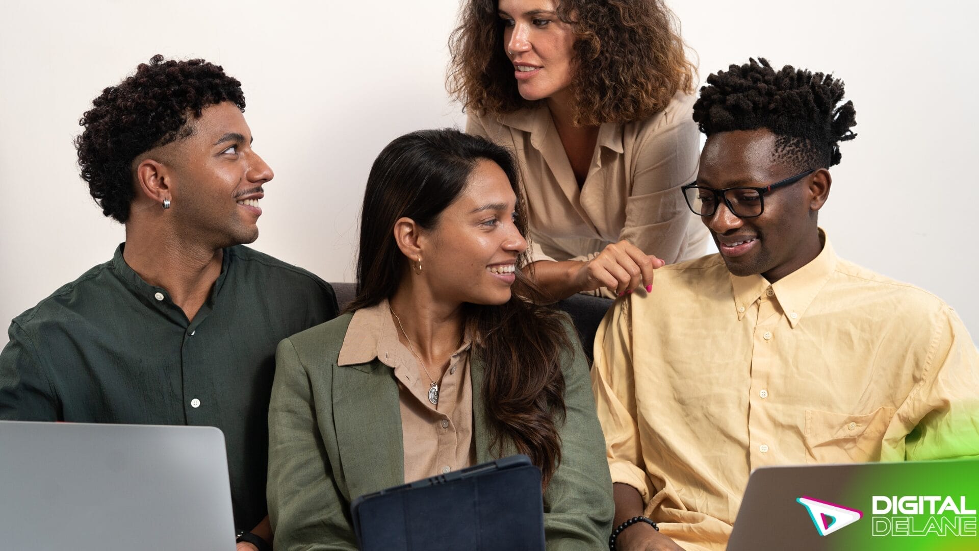 Three individuals collaborating on laptops while seated on a couch, symbolizing teamwork and digital engagement.