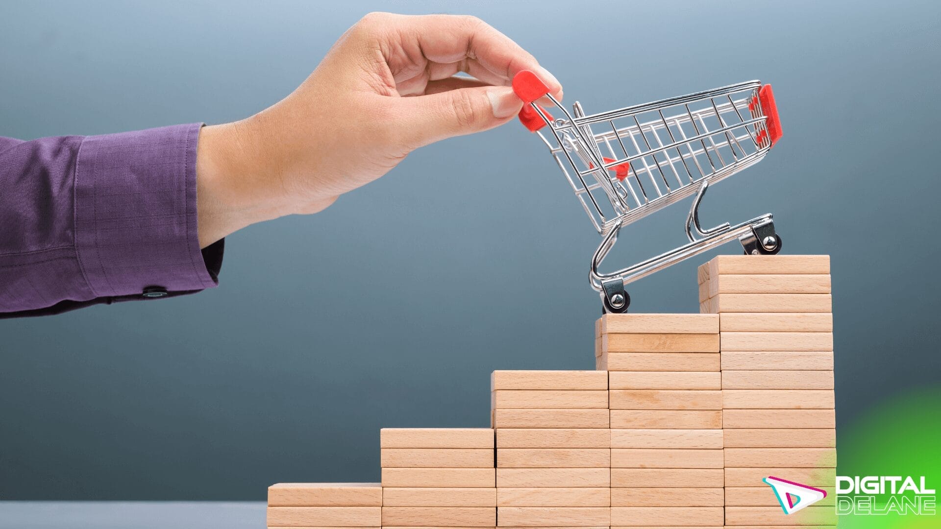 A hand holds a shopping cart atop wooden blocks, symbolizing the ease of visual search in boosting e-commerce sales.